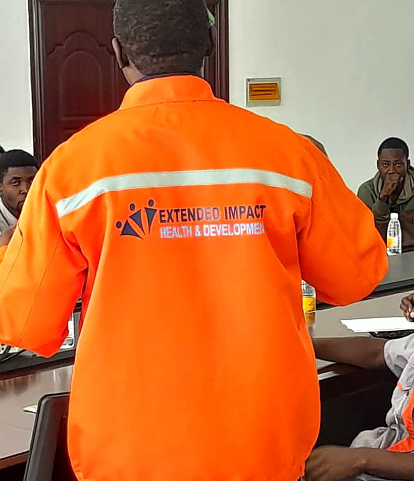 An EI4HD trainer, wearing a branded coverall, leading an Occupational Health & Safety training session for industry staff.